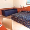 Camera con letto matrimoniale e divano blu.
