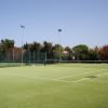 Un campo da tennis all'aperto con erba sintetica.