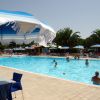 Una piscina all'aperto con persone e ombrelloni.