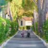 Vialetto fiorito con due bambini in bici.