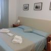 Camera da letto con letto matrimoniale, comodini e quadri alle pareti.