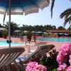 Piscina circondata da sdraio e ombrelloni blu.