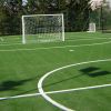 Campo da calcio in erba artificiale con porte.