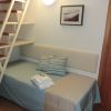 Letto singolo con cuscini a righe sotto scala.