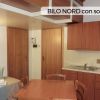Cucina con scala verso soppalco e tavolo.