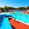 Piscine affollate con scivolo e ombrelloni.