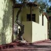 Vialetto con case giallo chiaro e un albero che cresce vicino al muro.