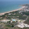 Vista aerea della spiaggia e del litorale con verde e strutture.