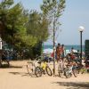 Spiaggia con biciclette parcheggiate e persone.