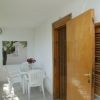 Veranda con tavolo e sedie bianche all'esterno.