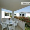 Veranda con tavolo e sedie bianche.
