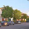 Una strada con auto parcheggiate e alberi.