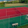 Campo da tennis rosso all'aperto vicino al mare.
