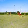 Giovani giocano a calcio su un campo all'aperto.
