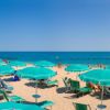 Spiaggia con ombrelloni verdi sotto un cielo terso.