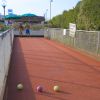 Due persone giocano a bocce su un campo all'aperto.