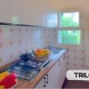 Cucina con piastrelle a fiori e fornello.