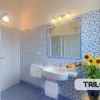 Bagno con piastrelle blu e fiori gialli.