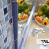 Dettaglio di mosaico blu con lavabo e fiori.