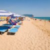 Ombrelloni e lettini blu su una spiaggia sabbiosa.