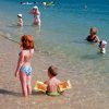Bambini e adulti giocano nell'acqua del mare.