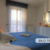 Stanza con letto e copriletto blu, tendaggi chiari.