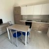 Cucina moderna con tavolo, sedie blu e mobili in legno chiaro.