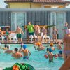 Attività di gruppo in una piscina all'aperto con molti bambini e alcuni adulti.