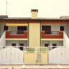 Complesso residenziale con portone bianco e terrazze rosse su due livelli.