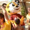 Persone ballano con un personaggio in costume di tigre.