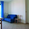 Interno con divano blu e sedia di legno.