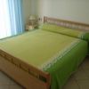 Letto matrimoniale con copriletto verde.
