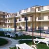 Complesso residenziale con piscina e sedie a sdraio.