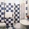 Bagno con piastrelle a scacchi blu e bianche, doccia e lavabo.