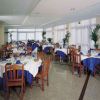 Ristorante luminoso con tavoli apparecchiati, tovaglie blu.