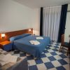 Camera d'albergo con letto matrimoniale e pavimento a scacchi.