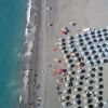 Spiaggia con ombrelloni e bagnanti in riva al mare.