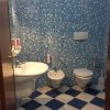 Bagno con piastrelle blu, lavandino, bidet e wc.