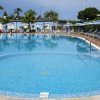 Piscina circondata da lettini e ombrelloni blu.