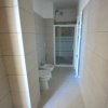 Bagno stretto con doccia e sanitari.