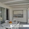 Patio con tavolo, sedie e cucina all'aperto.