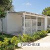 Bungalow moderno bianco con veranda e giardino.