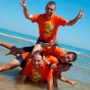 Persone sorridenti fanno una piramide in acqua.