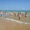 Persone fanno esercizi nell'acqua sulla spiaggia.