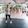 Una persona su un palco davanti a un gruppo che balla.