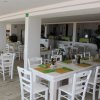 Ristorante interno con tavoli apparecchiati, tono bianco e verde.