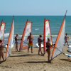 Persone praticano windsurf sulla spiaggia.