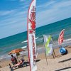 Spiaggia con bandiere e mare al sole.