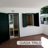 Terrazzino con porte e finestre verdi.