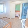 Una stanza con letto singolo, scrivania e porta che conduce a un bagno.
